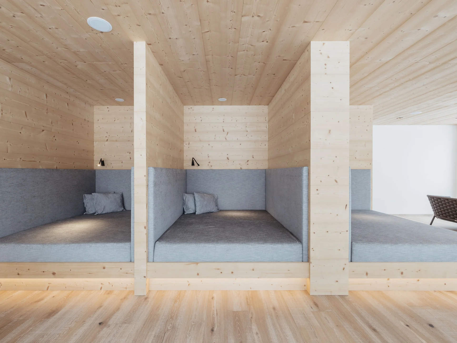 Il vostro hotel con spa in Alta Badia: il Nature Hotel Delta Nicchie moderne in legno con cuscini grigi in una stanza luminosa