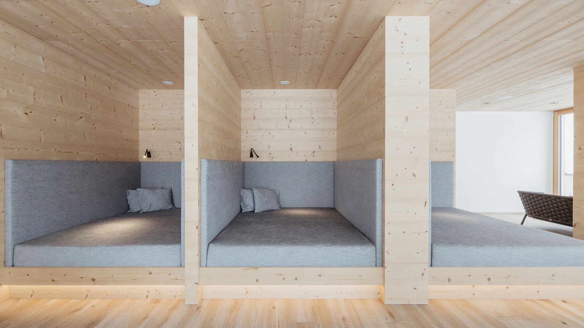 Die schönsten Eindrücke aus dem Nature Hotel Delta Moderne Holznischen mit grauen Polstern und Kissen in einem hellen Raum