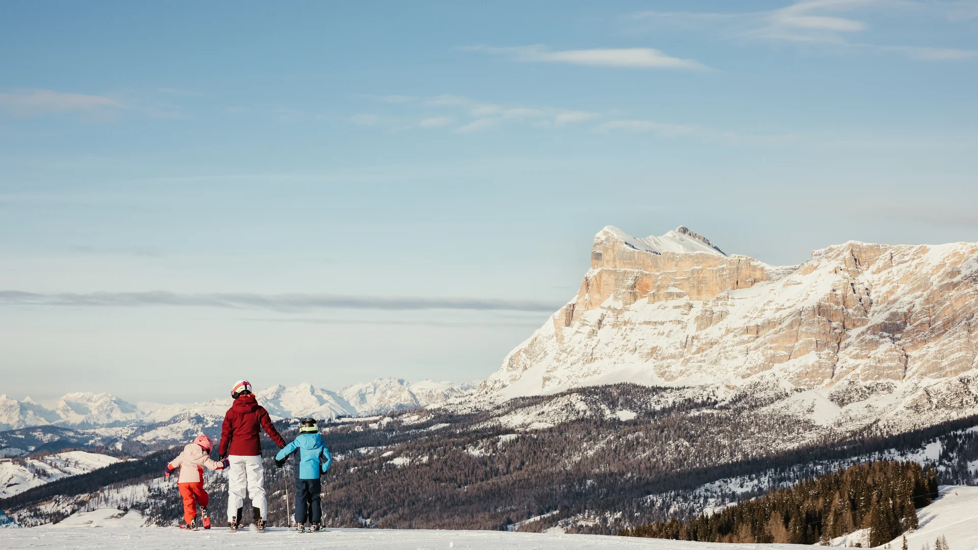 Die schönsten Eindrücke aus dem Nature Hotel Delta Familie mit Kindern auf Skiern vor verschneiten Bergen