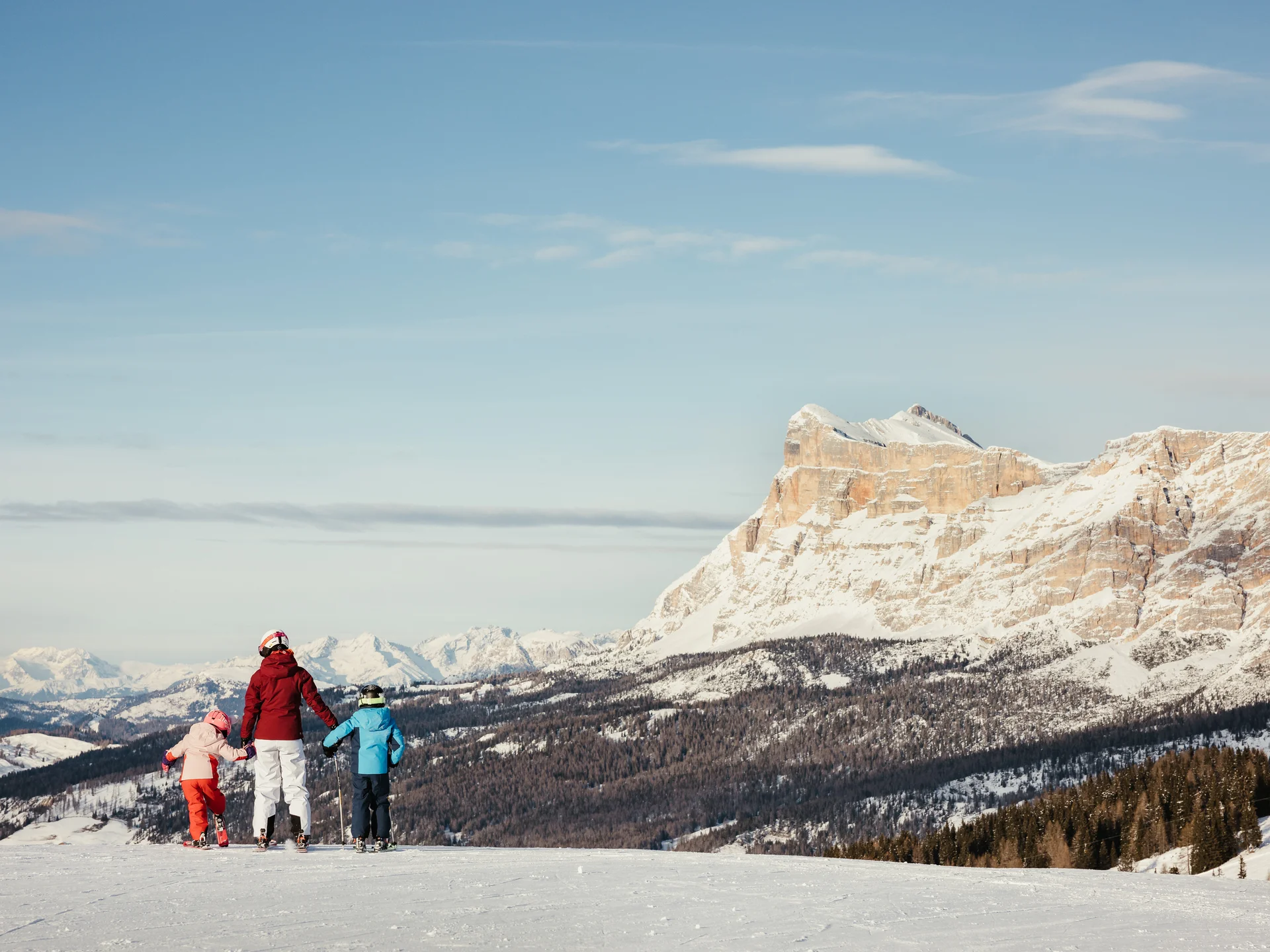 Das ist sehenswert in der Umgebung des Nature Hotel Delta. Familie mit Kindern auf Skiern vor verschneiten Bergen