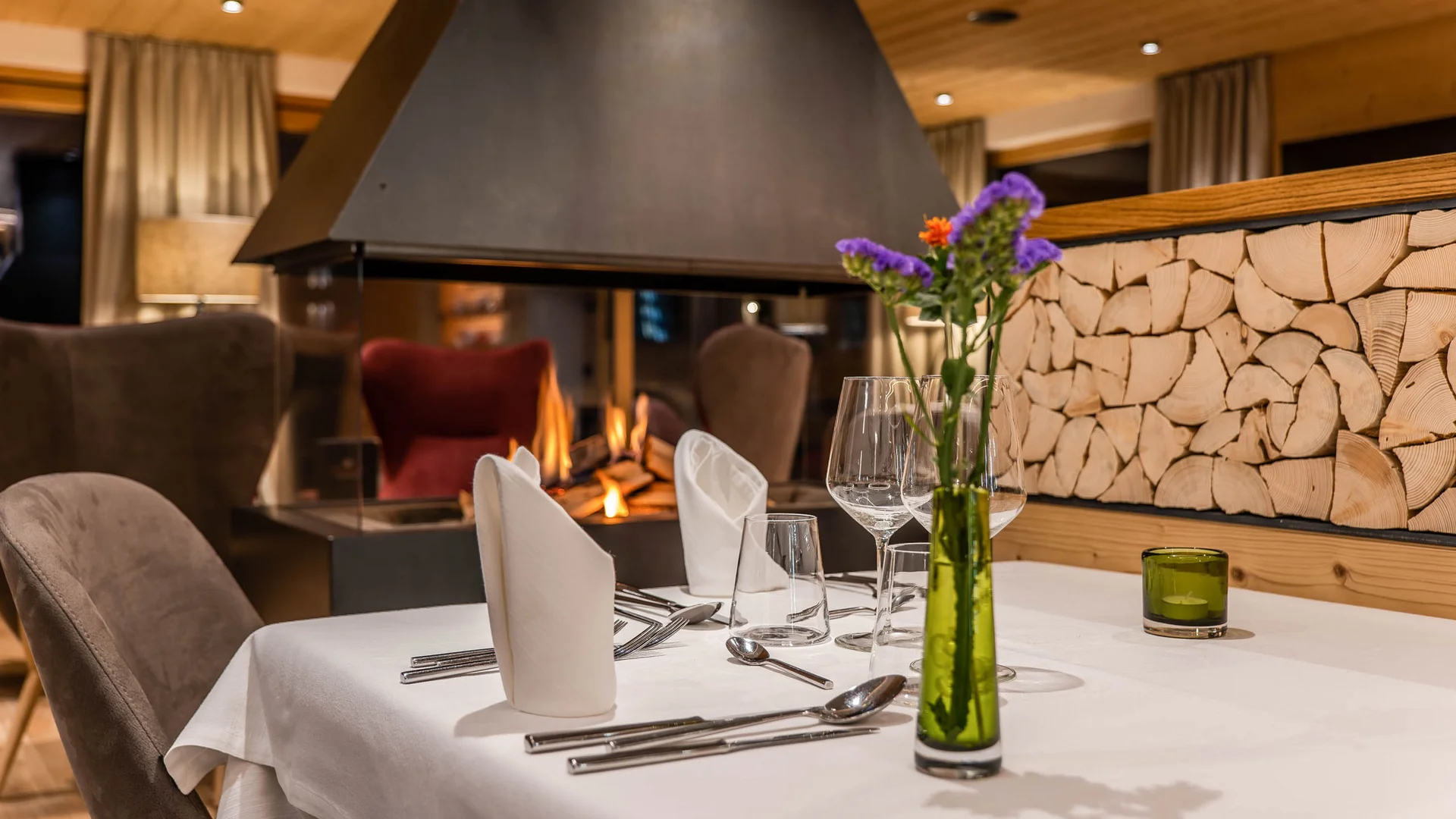 Die schönsten Eindrücke aus dem Nature Hotel Delta Eleganter gedeckter Tisch vor Kamin in gemütlichem Restaurant