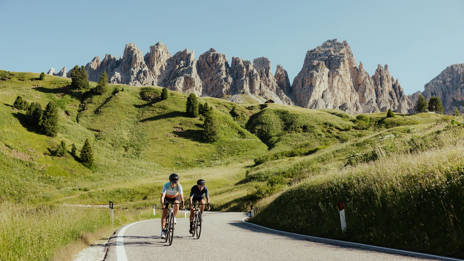 Die schönsten Eindrücke aus dem Nature Hotel Delta Zwei Radfahrer auf Bergstraße mit grünen Hügeln und Felsen im Hintergrund