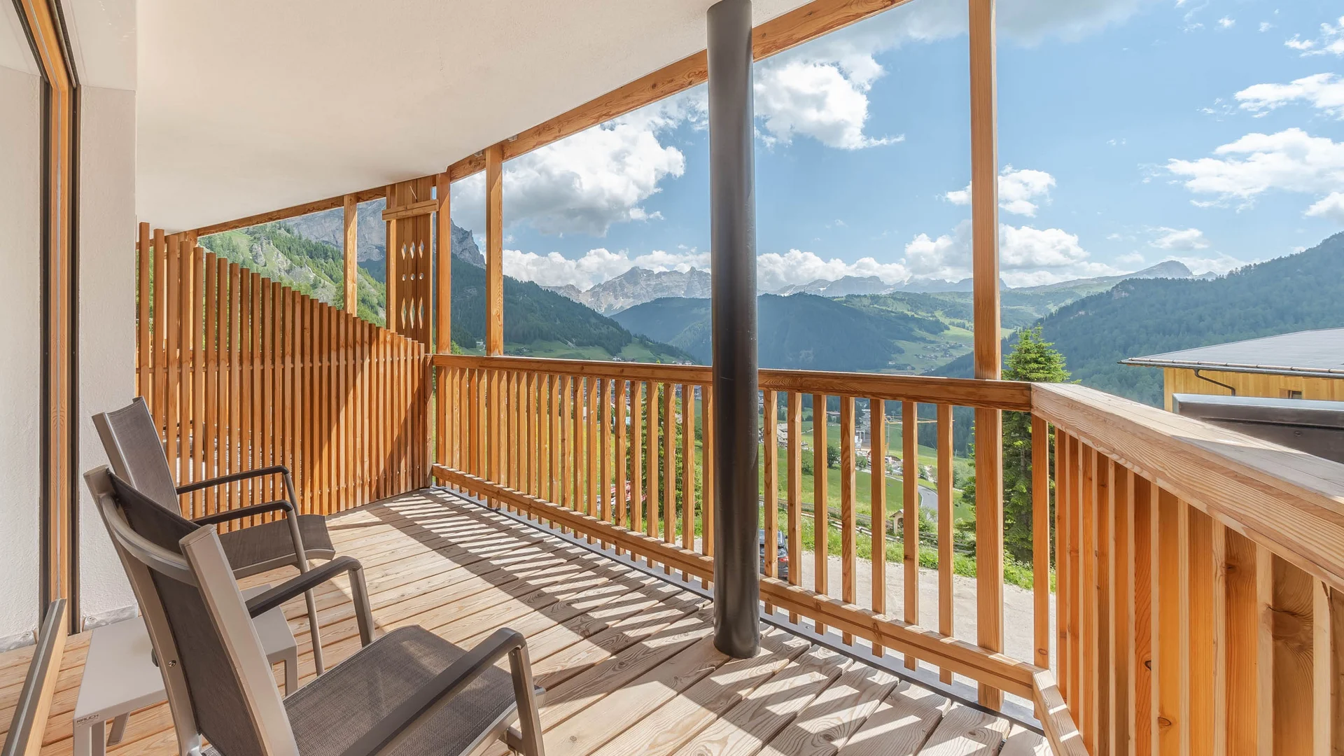 Die schönsten Eindrücke aus dem Nature Hotel Delta Balkon mit zwei Stühlen und Blick auf Berge bei sonnigem Wetter
