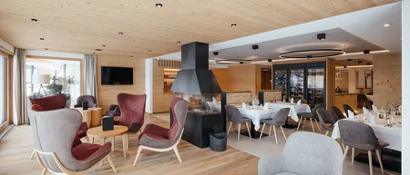 Gemütlicher Hotel-Loungebereich mit Sesseln und Kamin