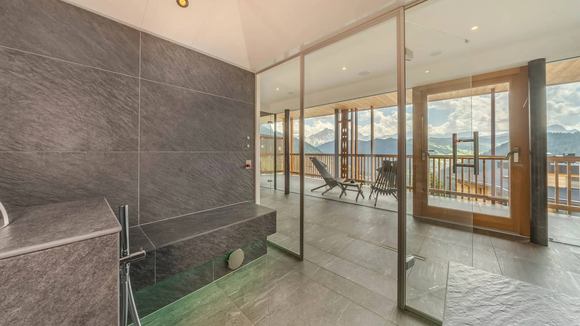 Die schönsten Eindrücke aus dem Nature Hotel Delta Moderner Wellnessbereich mit Sauna und Bergblick durch Glaswand