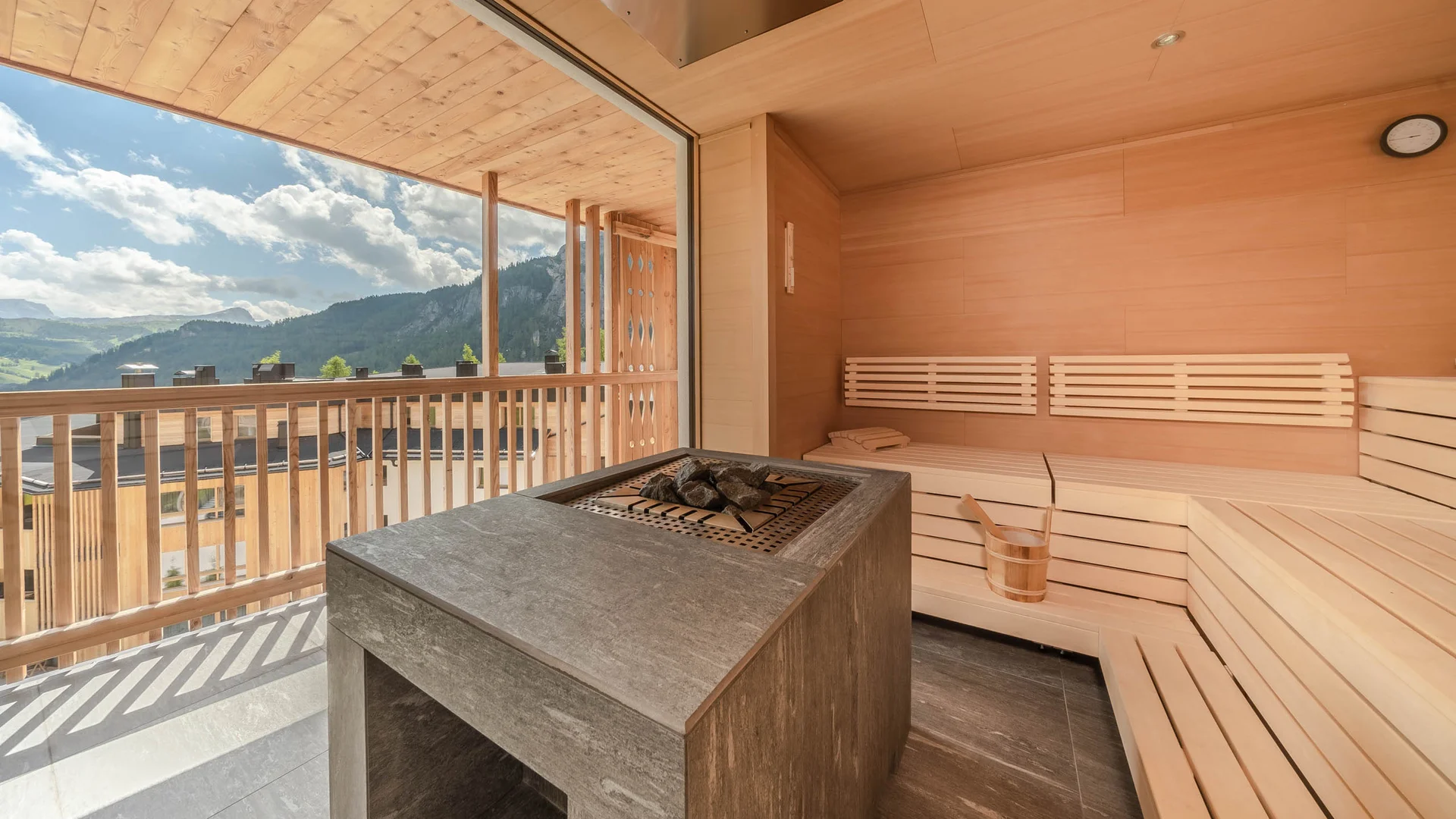 Sauna mit Holzbänken und Bergblick durch große Fenster