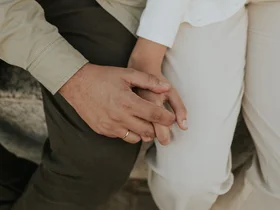 Nahaufnahme von zwei Personen, die sich an den Händen halten