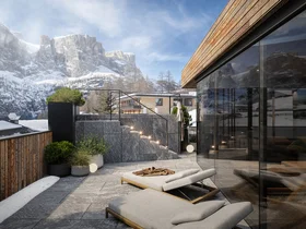 Terrasse mit Liegestühlen und Bergblick im Schnee bei klarem Himmel