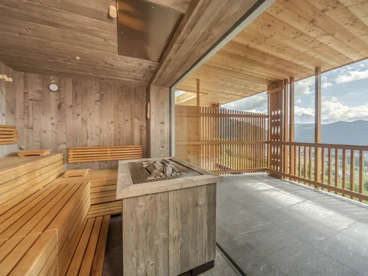 Sauna mit Holzinterieur und großer Glasfront mit Bergblick
