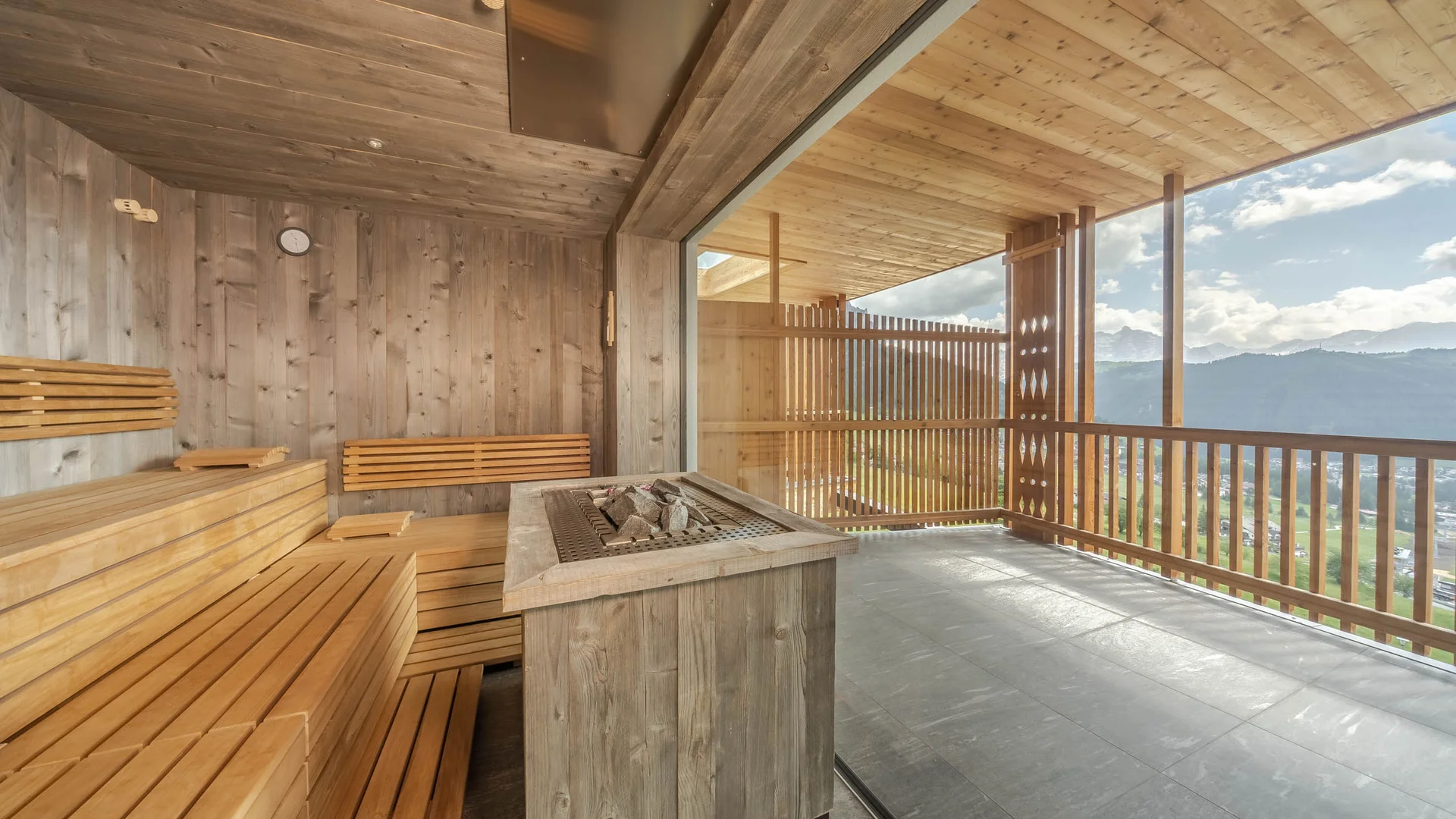Die schönsten Eindrücke aus dem Nature Hotel Delta Sauna mit Holzinterieur und großer Glasfront mit Bergblick
