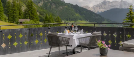 Terrasse mit gedecktem Tisch und Bergblick bei bewölktem Himmel