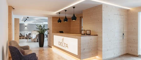 Moderner Empfangsbereich mit Holztheke und Sitzbereich im Hotel Delta