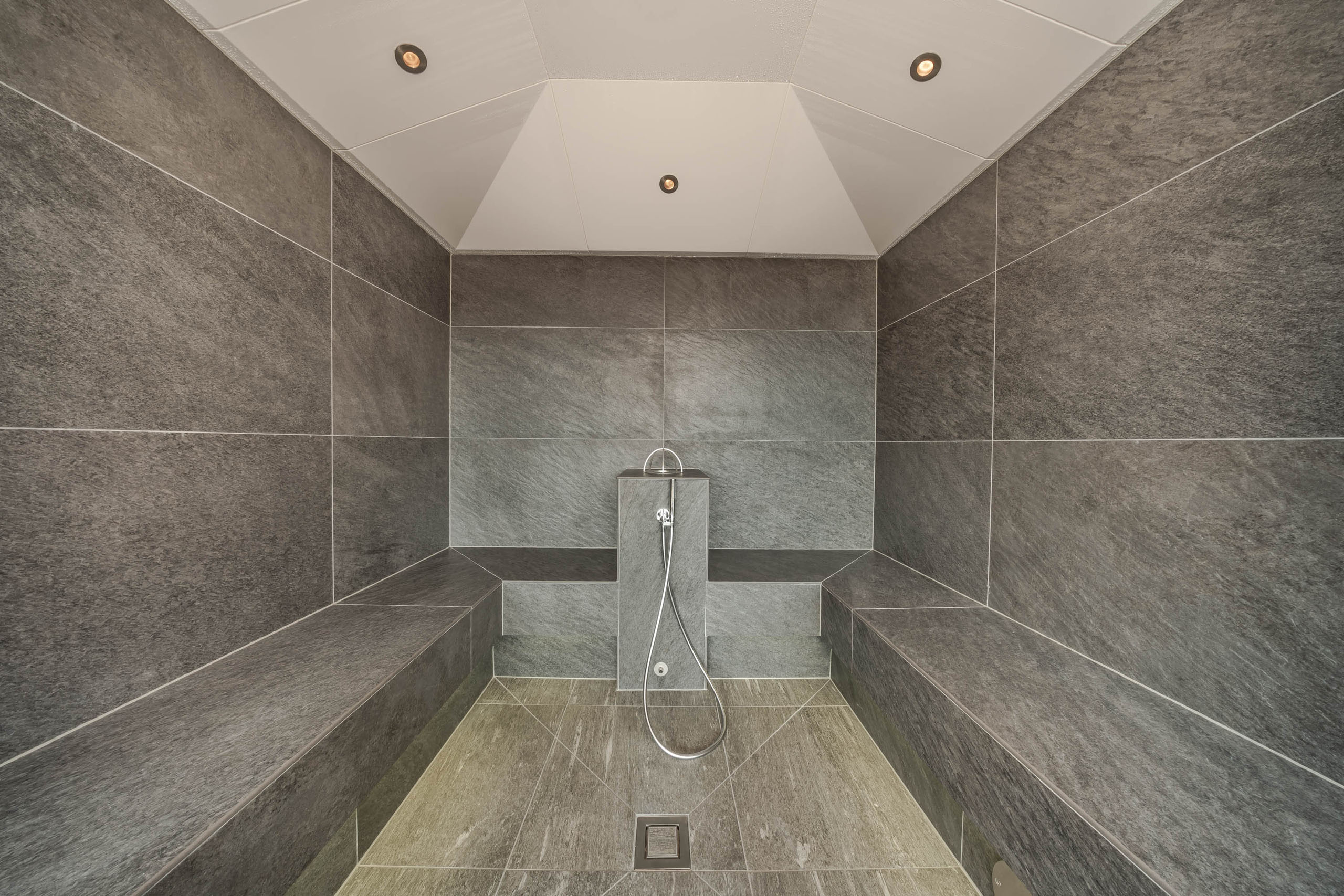 Il vostro hotel con spa in Alta Badia: il Nature Hotel Delta Sala vapore moderna con piastrelle grigie e panche laterali