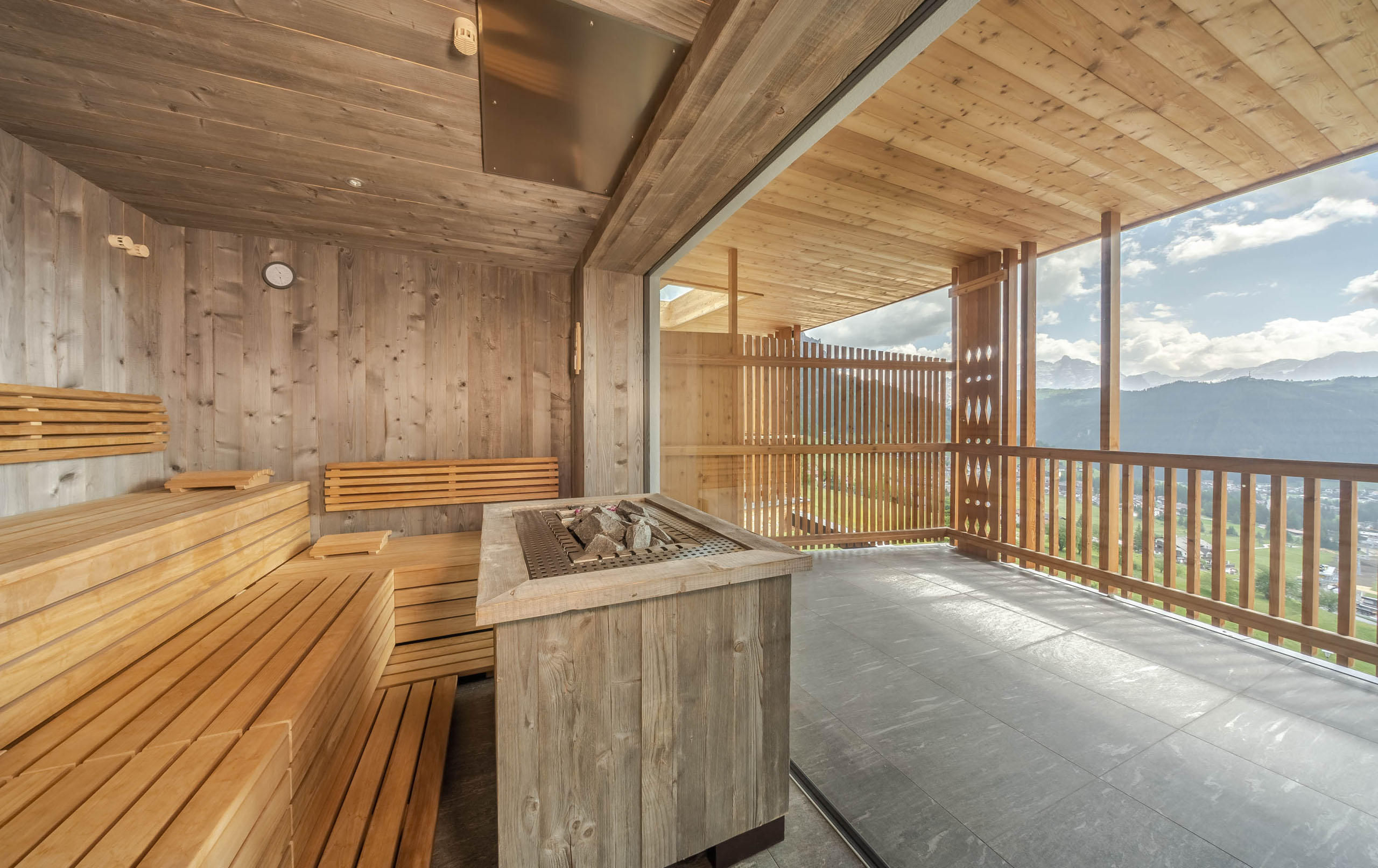 Genuss und Wellness im Nature Hotel Delta in Alta Badia Sauna mit Holzinterieur und großer Glasfront mit Bergblick